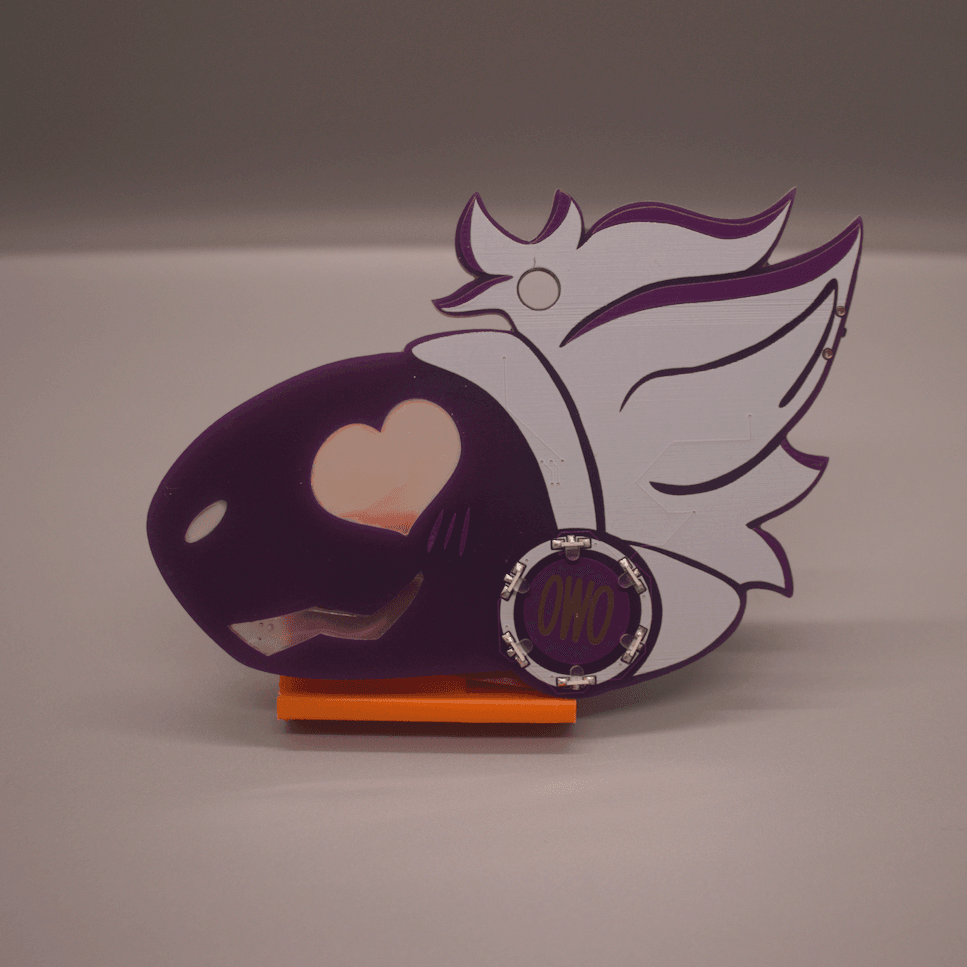 A purple PCB badge in the shape of a protogen's head. They have a heart shaped eye, a nose and a mouth, which are filled in with hot glue. They have white hair, and a circle of LEDs on their cheek, with the letters "OWO" in the center of them.